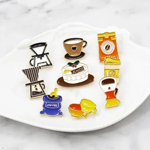 Detail view of coffee and dessert enamel pins displayed on a white shell porcelain plate