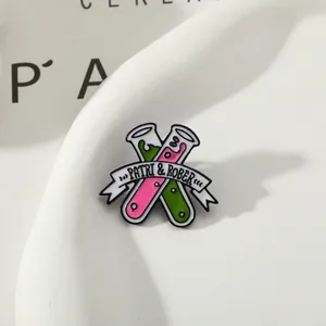 Detail of enamel pin with chemical test tubes and white ribbon on textured tray