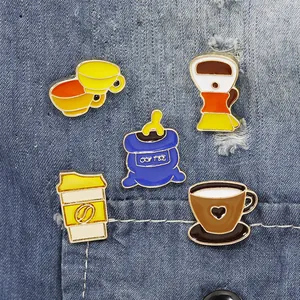 Detail of five coffee enamel pins pinned on blue denim pocket showing vintage design