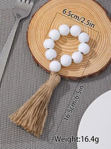 Detail view of wooden bead napkin ring with jute tassel showing dimensions and rustic texture