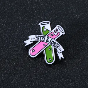 Scientific chemistry test tube enamel brooch with green and pink liquid and ribbon banner