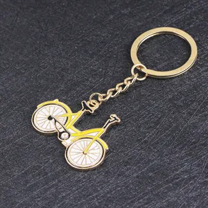 Portachiavi bici in lega dorata con smalto giallo su sfondo grigio testurizzato