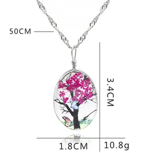 Vue détaillée du pendentif ovale en verre avec arbre de vie montrant les dimensions 3,4x1,8 cm