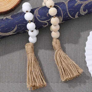 Detail of wooden bead napkin rings with natural jute tassels in white and wood colors