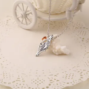 Macro view of vintage silver chain with marquise-cut crystal pendant on lace