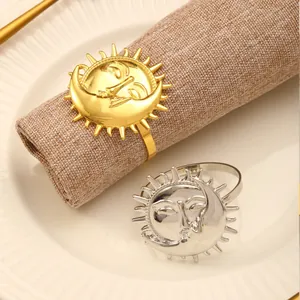 Artistic gold and silver sun moon napkin rings set on rustic table for holiday decor