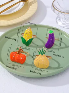 Dettaglio di quattro portatovaglioli a forma di verdura in smalto e metallo dorato