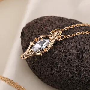 Macro detail of vintage gold pendant with marquise-cut crystal and baroque carvings