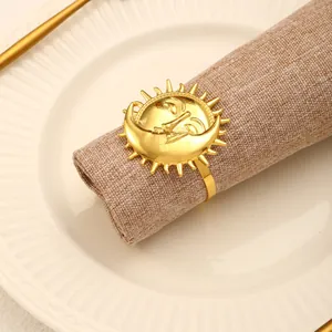 Detail of gold sun and moon face embossed napkin ring on a beige textured napkin