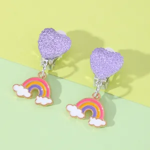 Detail shot of purple glitter heart and rainbow clip-on earrings for kids