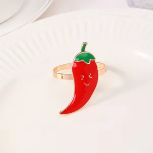 Portatovaglioli a forma di peperoncino rosso con sorriso su piatto di ceramica bianca