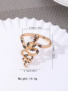 Detail of gold snake napkin ring with black rhinestones on a white plate