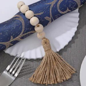 Detail of wooden bead napkin ring with jute tassel on a navy blue linen napkin