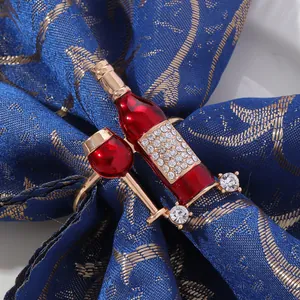 Golden napkin ring featuring red wine bottle and glass design with sparkling zircons