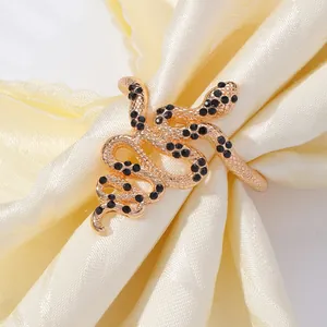 Gold snake napkin ring with black rhinestones on cream satin fabric for table decor