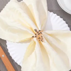 Golden snake napkin ring with black gemstones on a white plate with beige napkin