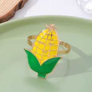 Dettaglio dell'anello portatovagliolo dorato con decorazione a forma di mais in smalto