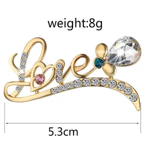 Detail view of golden LOVE brooch with rhinestones, 5.3cm length and 8g weight