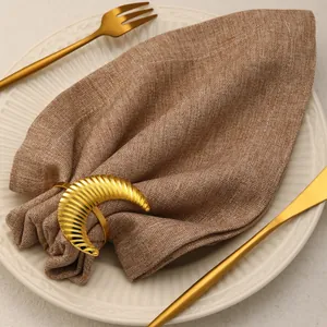 Elegant gold crescent moon napkin ring with ribbed texture on table setting