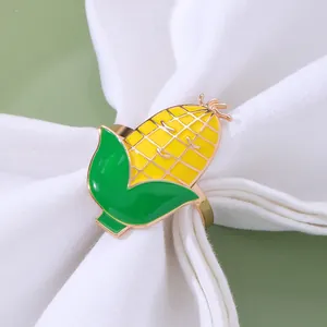 Dettaglio di un portatovagliolo a forma di mais giallo su un tovagliolo bianco