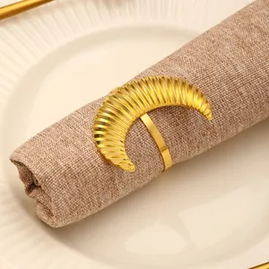 Detailed view of golden moon napkin ring with ribbed texture on a linen napkin
