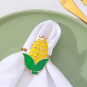 Dettaglio portatovagliolo a forma di mais giallo con viso sorridente su stoffa bianca