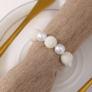 Dettaglio del portatovagliolo di perle fatto a mano con perle bianche su lino