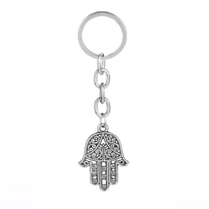 Detailed macro of vintage silver Hamsa hand keychain with hollow floral carving patterns