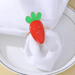 Dettaglio portatovagliolo a carota in smalto rosso con simpatico viso sorridente inciso
