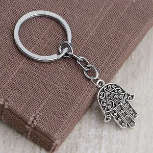 Retro hollow Hamsa Hand keychain in vintage silver metal with intricate carving