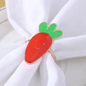 Dettaglio dell'anello portatovagliolo a forma di carota sorridente su tovagliolo bianco