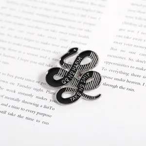 Detail der Emaille-Brosche mit Schlangen-Motiv und Do No Harm Schriftzug