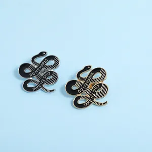 Detail der Schlangen-Emaille-Pins in Gold und Silber mit Do No Harm und Take No Shit Slogan
