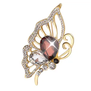 Elegant gold butterfly brooch with purple pear-shaped gemstone and sparkling crystals