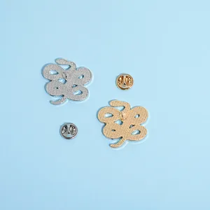 Set aus goldenen und silbernen Schlangennadeln mit Schmetterlingsverschlüssen auf Blau