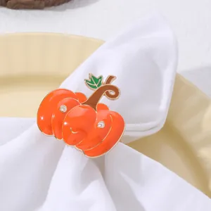 Dettaglio macro del portatovagliolo a zucca con smalto arancione e foglia verde su panno