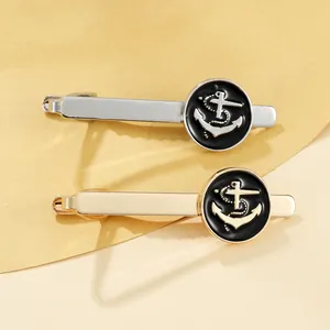 Detailed view of silver and gold anchor cufflinks and tie clips with black circular badges
