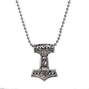Macro view of vintage silver Mjölnir pendant with intricate Viking Norse engravings