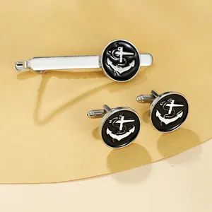Macro view of silver nautical tie clip and anchor cufflinks set with black round inlay