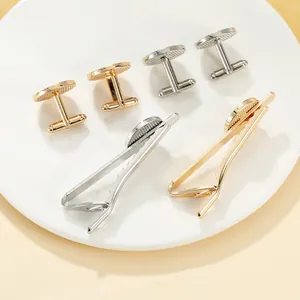 Detailed view of men's anchor cufflinks and tie clip set in gold and silver finishes