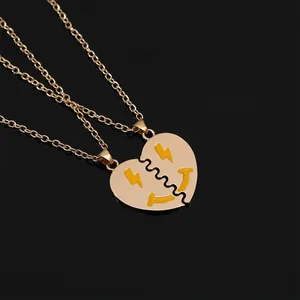 Detail of golden BFF heart necklaces with smile face and lightning bolt patterns