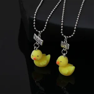 Detail von BFF-Halsketten mit gelben beflockten Enten und BEST FRIENDS Metallanhängern