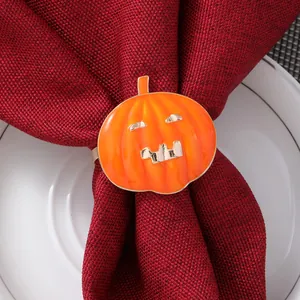 Dettaglio macro di un portatovagliolo a forma di zucca arancione su un tovagliolo rosso