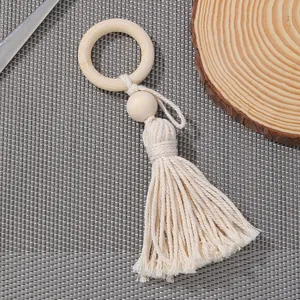 Portatovaglioli bohémien con perline di legno beige e nappe fatte a mano su tessuto grigio