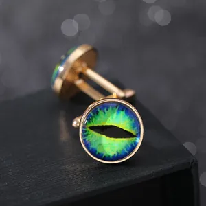 Dettaglio macro di gemelli dorati con cabochon in vetro raffiguranti occhi di drago