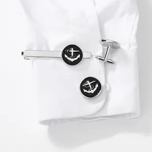 Men's silver anchor cufflinks and tie clip set shown on a white formal shirt cuff