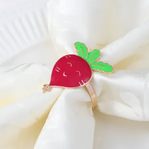 Dettaglio portatovagliolo a forma di carota in lega smaltata rossa su lino bianco
