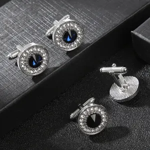 Macro shot of silver cufflinks with blue and black crystals and pavé zircon detailing