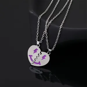 Detail of silver BFF heart necklaces featuring purple enamel smiley faces and lightning bolts