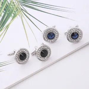 Macro detail of silver round cufflinks with black and blue zircon stones and halo crystals